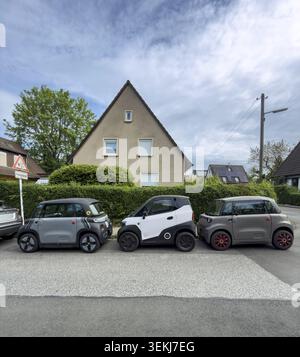 Trois petites voitures électriques se garent en rangée devant une maison unifamiliale à Essen, en Allemagne Banque D'Images
