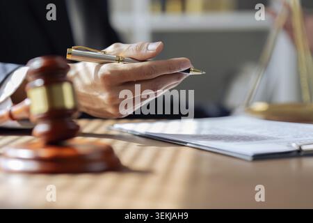 Fermer les mains de l'avocat tenant le stylo, signant dans le formulaire de livre blanc ou l'application pour confirmer et traiter l'accord de contrat Banque D'Images