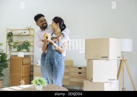 Couples indiens mariés propriétaires détenant un modèle de maison déménageant dans une nouvelle maison. concept de relocalisation Banque D'Images