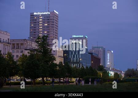 Marszalkowska rue à Varsovie pendant l'heure bleue. Gratte-ciel modernistes Ściana Wschodnia avec des enseignes au néon McDonald's, Hisense et Novotel Banque D'Images
