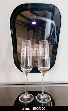 vue de deux flûtes à champagne sur une table en bois devant une fenêtre sur un avion Banque D'Images