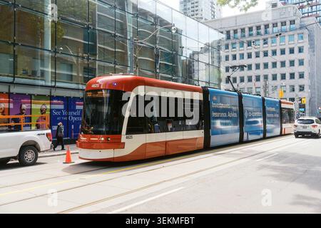 Toronto, Canada - 26 mai 2026 : tramway rouge et blanc moderne sur Downtown City Street Banque D'Images