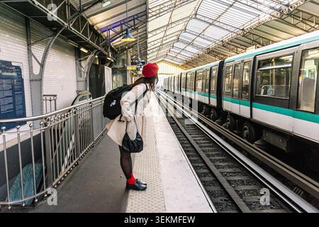 Femme voyageuse en solo explorant la plate-forme du métro parisien Banque D'Images