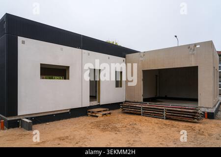 Bâtiment résidentiel moderne en construction avec façade minimaliste et structure de garage ouvert Banque D'Images
