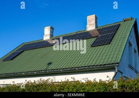 Système résidentiel de panneaux solaires sur le toit installé sur le toit métallique pour la maison de production d'énergie renouvelable Banque D'Images