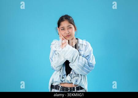 Jeune femme fatiguée tenant la main sur sa joue l'air épuisée Banque D'Images