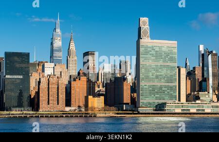 Horizon Midtown Manhattan à travers l'East River à New York. Paysage urbain de gratte-ciel modernes, de monuments et d'immeubles de bureaux à la lumière du matin Banque D'Images