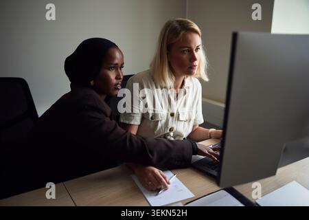Vue en angle élevé d'une experte technologique féminine focalisée travaillant sur ordinateur au bureau Banque D'Images