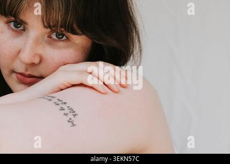 Gros plan d'une belle jeune femme appuyée sur le bras Banque D'Images