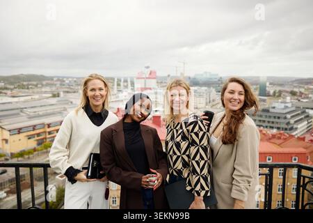 Portrait de diverses femmes d'affaires posant ensemble sur la terrasse contre le paysage urbain Banque D'Images