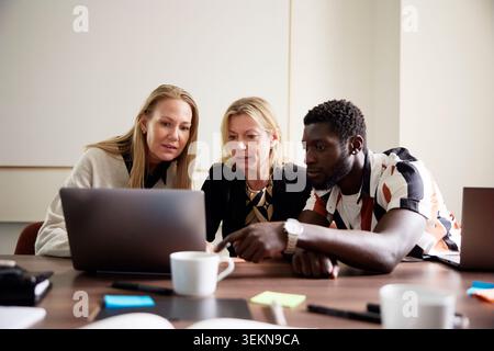 Hommes et femmes employés d'entreprise travaillant sur ordinateur portable dans la salle de conseil de bureau Banque D'Images