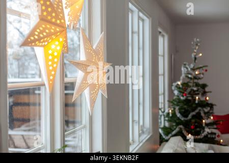 Lanternes en papier incandescentes suspendues près de la fenêtre pendant Noël dans le salon à la maison Banque D'Images