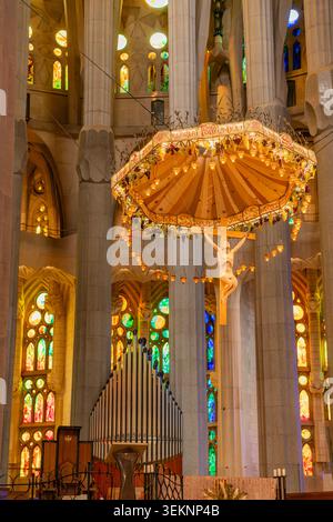 Barcelone, Espagne - 19 octobre 2025 : crucifix suspendu et verrière au-dessus de l'autel à l'intérieur de la Sagrada Familia Banque D'Images