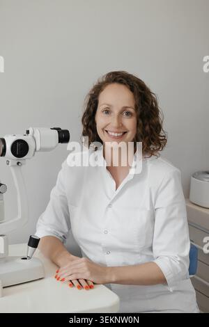 Médecin féminin utilisant le microscope dans le cadre moderne de la recherche de laboratoire médical Banque D'Images