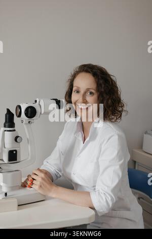 Médecin féminin utilisant le microscope dans le cadre moderne de la recherche de laboratoire médical Banque D'Images