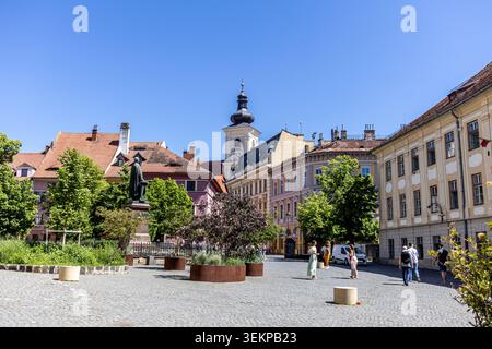 Une large vue extérieure horizontale d'une place médiévale pittoresque avec une place pavée de pierre, des arbres verts, des bâtiments colorés traditionnels, et un grand Banque D'Images