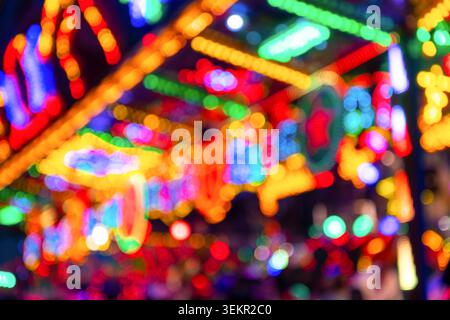 Lumières floues d'un carrousel avec éclairage LED coloré sur une foire amusante à Menden Allemagne. Lumières jaunes, vertes, bleues, rouges non focalisées à la nuit Banque D'Images