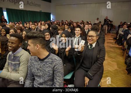 Les élèves sourient, applaudissent et enregistrent lors d'une représentation animée de l'Assemblée de l'école Humza Arshad. Londres. 26/03/2015. Banque D'Images