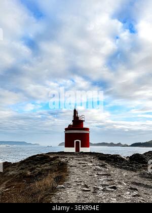 L'emblématique phare rouge vif de Punta Robaleira se trouve sur les falaises rocheuses escarpées de Costa da Vela, Cangas, Galice, Espagne. Océan Atlantique Banque D'Images