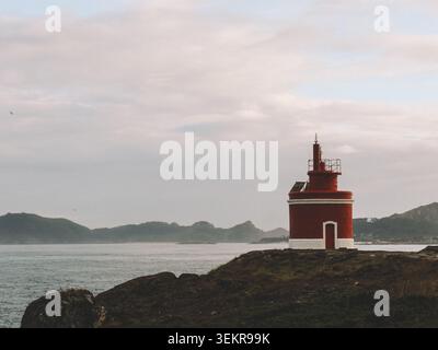 L'emblématique phare rouge vif de Punta Robaleira se trouve sur les falaises rocheuses escarpées de Costa da Vela, Cangas, Galice, Espagne. Océan Atlantique Banque D'Images