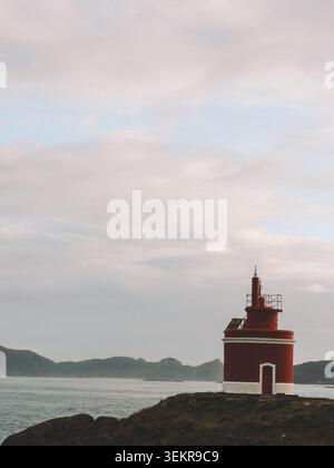 L'emblématique phare rouge vif de Punta Robaleira se trouve sur les falaises rocheuses escarpées de Costa da Vela, Cangas, Galice, Espagne. Océan Atlantique Banque D'Images