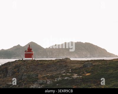 L'emblématique phare rouge vif de Punta Robaleira se trouve sur les falaises rocheuses escarpées de Costa da Vela, Cangas, Galice, Espagne. Océan Atlantique Banque D'Images