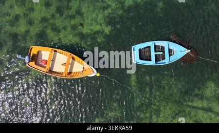 Vue aérienne de deux petits bateaux en bois flottant sur une eau verte claire près de l'Ile Callot à Carantec, Bretagne, France. Banque D'Images