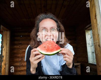 La femme voyageant aime la pastèque fraîche dans le cadre confortable de la cabine pendant l'escapade d'été Banque D'Images