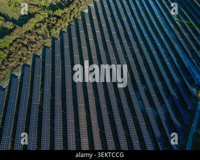 La ferme solaire contient des rangées de panneaux photovoltaïques produisant de l'électricité en plein soleil. Banque D'Images