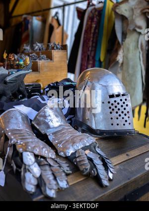 Dijon France 1er juin 2026. Un authentique casque de chevalier médiéval et des gants blindés en acier gisant sur un comptoir d'exposition sur un marché en plein air historique local Banque D'Images