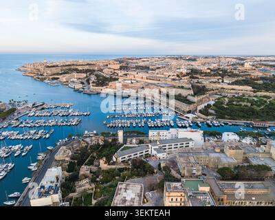 Vue aérienne de la ville historique de la Valette et du port rempli de yachts blancs et de voiliers amarrés près de fortifications en pierre à Malte. Banque D'Images