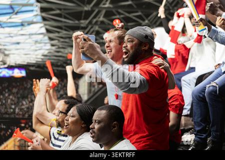Divers fans excités de gagner un billet pour les Paris en direct après le coup de sifflet final, match de football dramatique rempli de tension et d'excitation. Les amis célèbrent la victoire chanceuse sur l'application de Paris, l'adrénaline. Banque D'Images