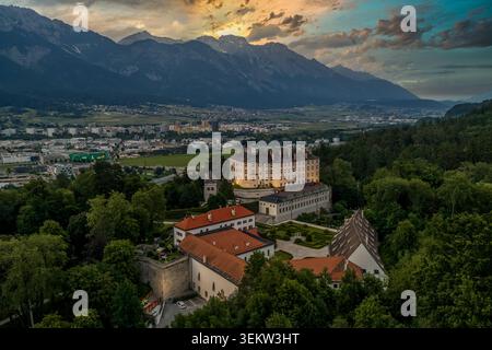 Vue aérienne par drone du Schloss Ambras (château d'Ambras), le célèbre palais Renaissance d'Innsbruck, capturé à l'heure d'or avec le Karwendel et Nordke Banque D'Images