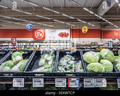 MONTIGNY, FRANCE - 4 MARS 2026 : des légumes frais sont exposés dans une allée de supermarché français à Montigny, France, avec chou, laitue, étiquette de prix Banque D'Images