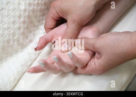 SPA salon et massage. Salle de massage. Un massothérapeute travaille avec une jeune femme. Massage des mains. Banque D'Images