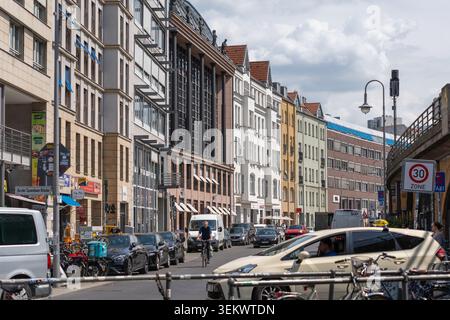 Allemagne, Berlin, 2 juin 2026. Les voitures se déplacent dans une rue berlinoise bordée de bâtiments mixtes et d'une structure ferroviaire surélevée. Un panneau zone 30, cycliste an Banque D'Images