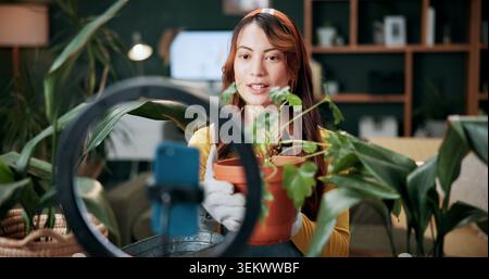 Jardinage, femme et plantes dans la maison avec éclairage annulaire, enregistrement de vidéo téléphonique et influenceur de médias sociaux. Personne, parler et création de contenu avec Banque D'Images