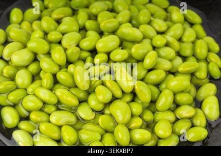 Fond texturé de bol de haricots edamame. Motif de soja vert, beaucoup de jeunes fèves de soja cuites, pois japonais bouillis en gros plan Banque D'Images