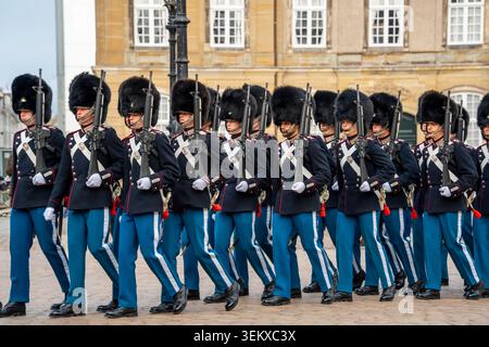 Cérémonie de relève de la garde au palais d'Amalienborg par les gardes de sauvetage royaux danois dans leurs uniformes cérémoniels bleu foncé avec des chapeaux en peau d'ours Banque D'Images