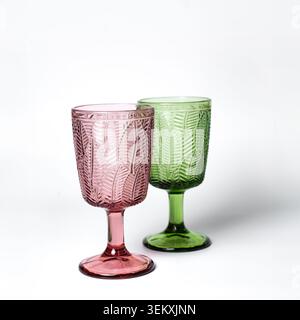 Gobelets en verre de couleur rose et verte sur fond blanc Banque D'Images
