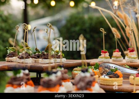 Variété de canapés et tartelettes sur la table de buffet extérieure Banque D'Images
