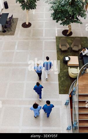Vue en grand angle de l'équipe médicale marchant dans le hall de l'hôpital Banque D'Images