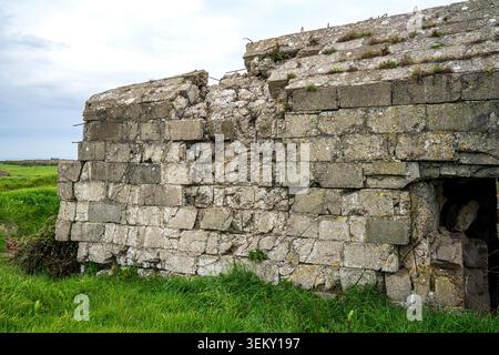 Vue rapprochée du mur extérieur d'un bunker à pointe du hoc, en Normandie, construit à partir de blocs de béton. La structure affiche un c partiel sévère Banque D'Images