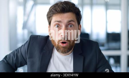 Portrait homme d'affaires caucasien d'âge moyen décollant des lunettes regardant la caméra étonné la réaction choquée de l'entreprise aux nouvelles au bureau étourdi mature Banque D'Images