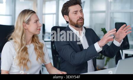 Deux collègues d'affaires caucasiens professionnels travaillant ensemble à la table de bureau homme d'affaires d'âge moyen partageant des idées parlent de travail d'entreprise Banque D'Images