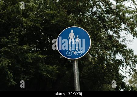 Panneau de signalisation bleu indiquant une voie partagée pour les piétons et les cyclistes. Concept de mobilité urbaine et de sécurité. Banque D'Images