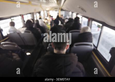 Déplacements des passagers assis dans un autobus urbain bondé intérieur pendant le trajet matinal vue arrière flou sur la scène des transports en commun de l'arrière de la tête. Banque D'Images
