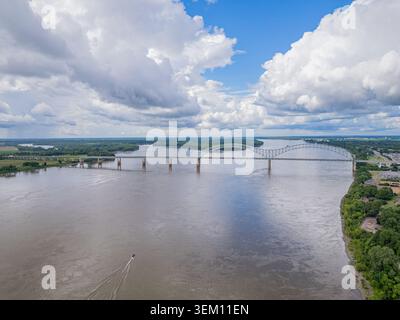 Vue aérienne à grand angle du pont Hernando de Soto enjambant le large fleuve Mississippi avec un bateau laissant un sillage dans l'eau. Banque D'Images