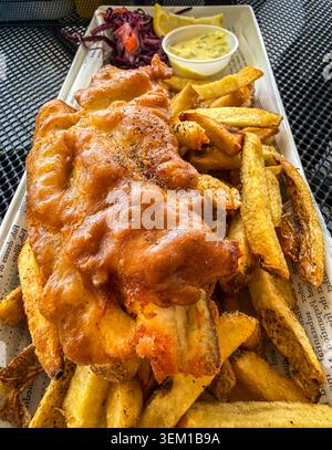 Pickerel frais légèrement pané et frit servi avec des frites rustiques coupées à la main et de la sauce tartare maison dans le patio extérieur. Banque D'Images