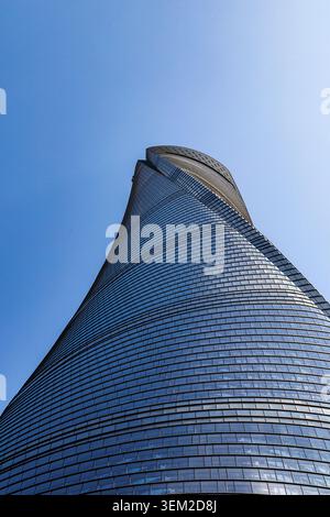 Vue en bas angle de la façade en verre torsadée de la tour de Shanghai qui monte en spirale dans le ciel bleu, Shanghai, Chine Banque D'Images